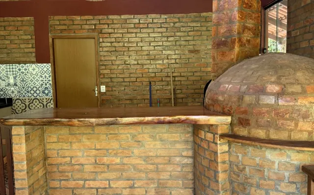 Bancada de tijolos e forno a lenha na cozinha coletiva