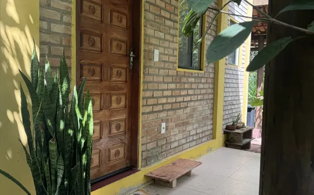 Entrada de um dos chalés, com porta de madeira entalhada